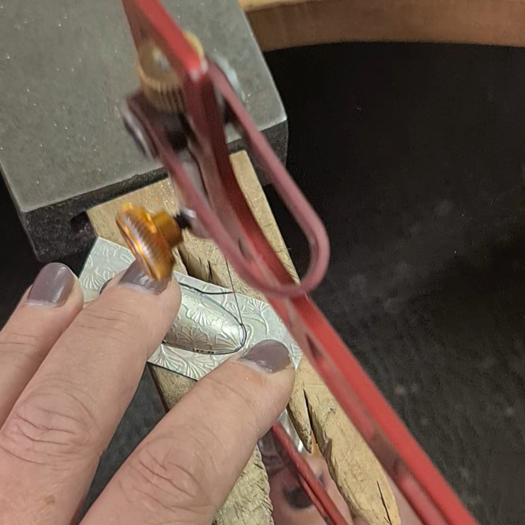 image shows an oval being sawn out from silver sheet